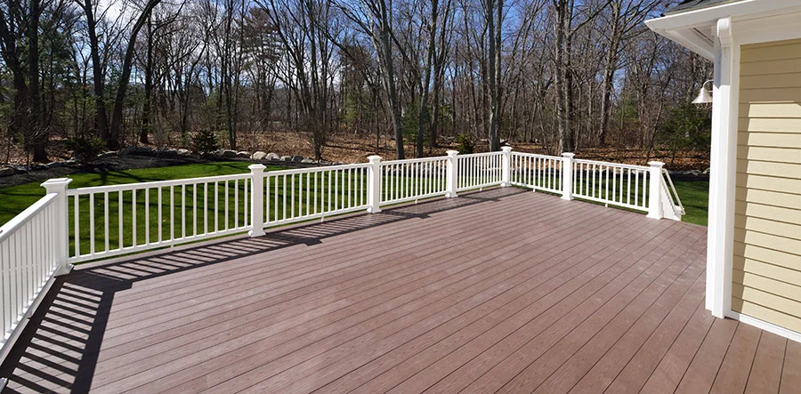 A wide, sprawling deck with white railing.